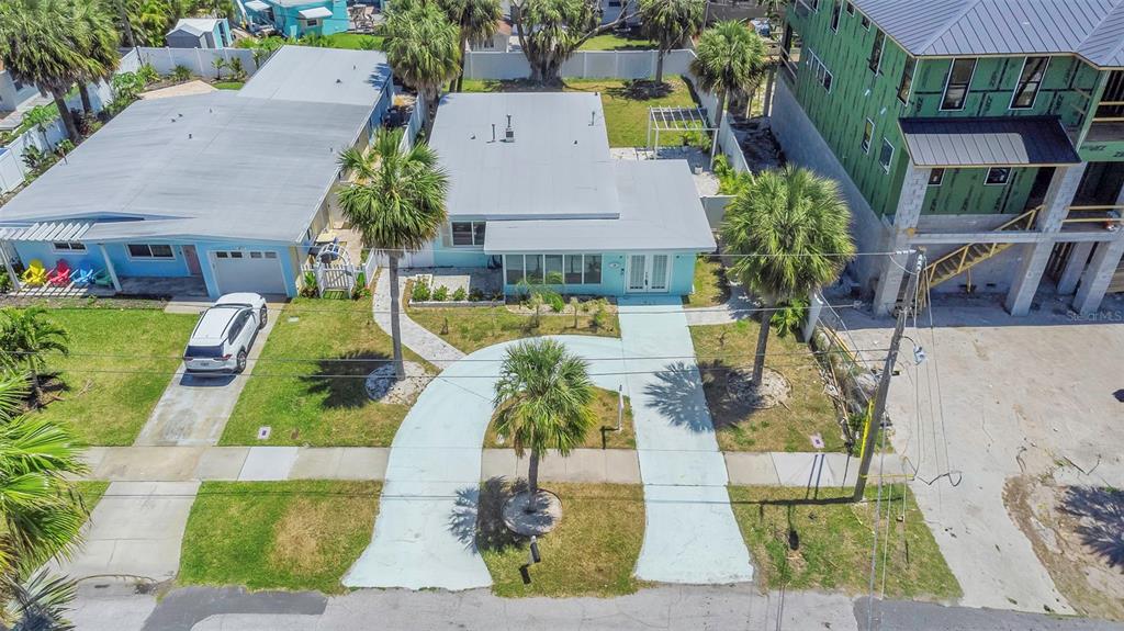 An aerial view shows a light blue house with a curved driveway and palm trees — 875 BRUCE AVENUE, CLEARWATER, FL