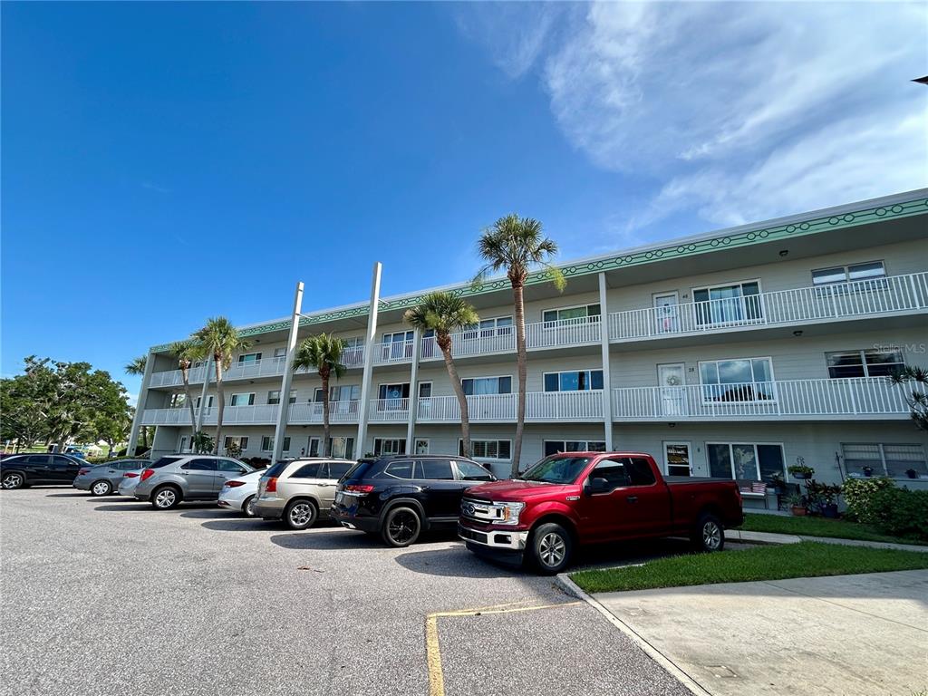 A multi-story apartment building with a parking lot in the foreground — 2070 WORLD PARKWAY BOULEVARD UNIT 36, CLEARWATER, FL