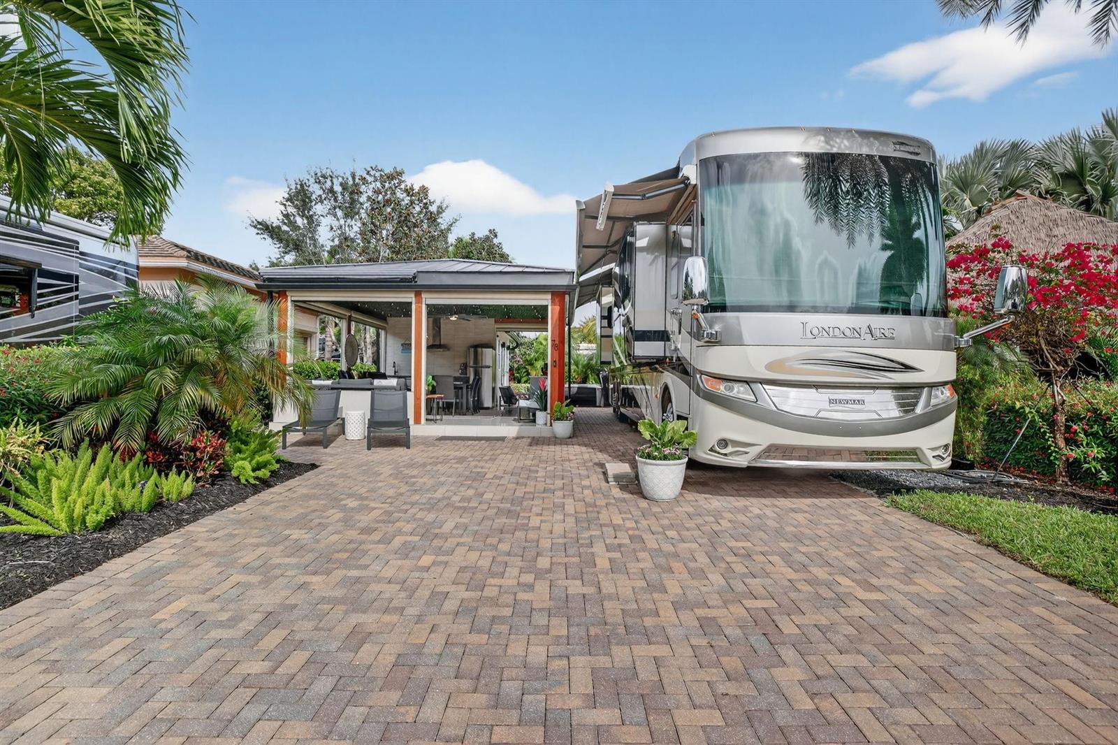 A paved driveway leads to a luxury motorhome parked beside an open-air outdoor living space — 78 S Cortez Drive # 78, Pompano Beach FL 33068, POMPANO BEACH, FL