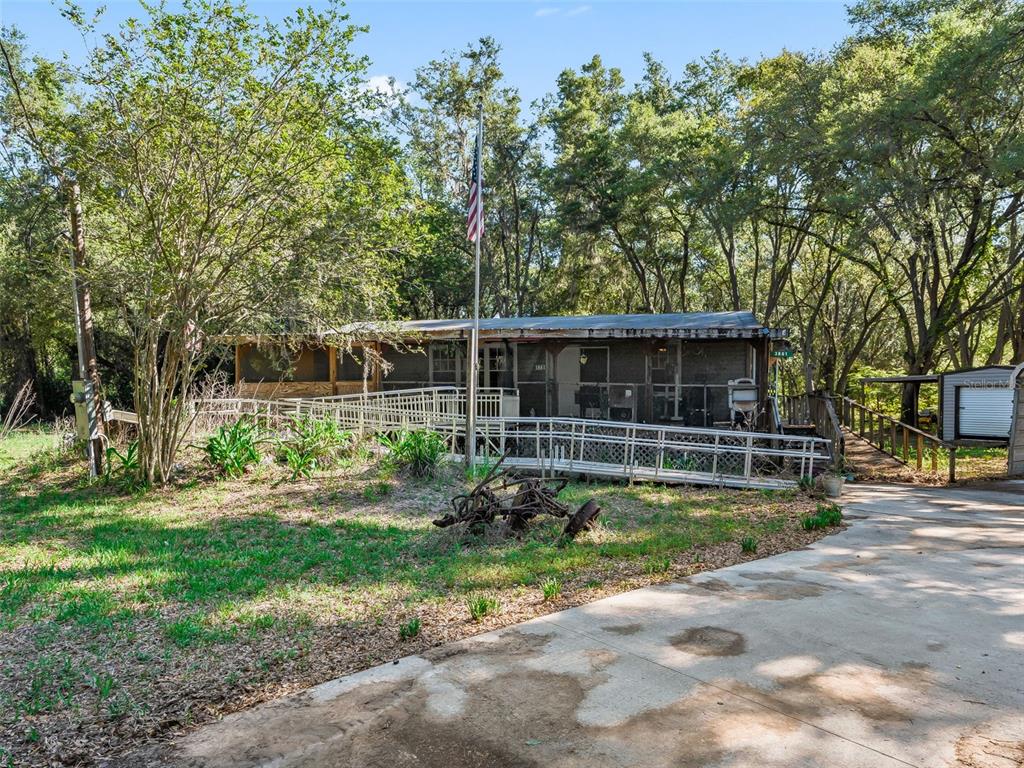 An outdoor kitchen area features a wooden counter, a sink, and a built-in double oven — 3861 CR 519, COLEMAN, FL