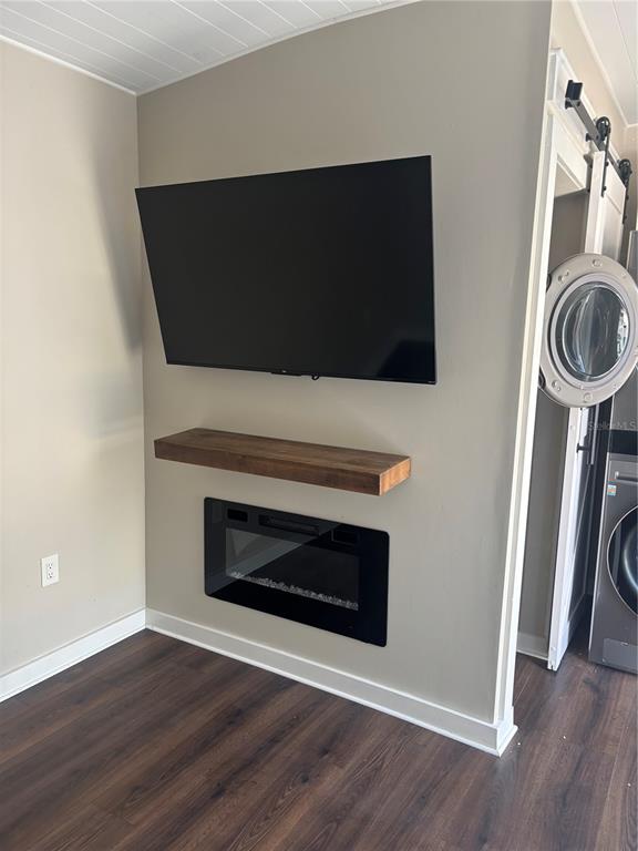 A wall-mounted television sits above a floating wooden shelf and a built-in electric fireplace — 20285 US HWY 27 UNIT 103, CLERMONT, FL