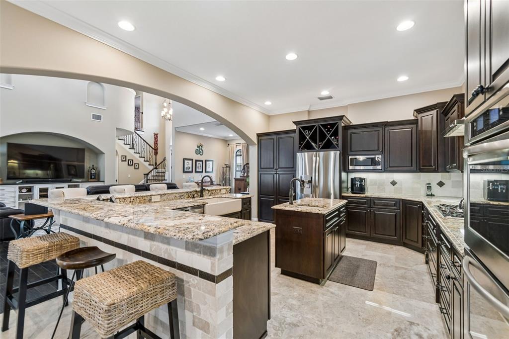 A kitchen with dark wood cabinets, granite countertops, a center island, and a breakfast bar — 6011 S 3RD STREET, TAMPA, FL