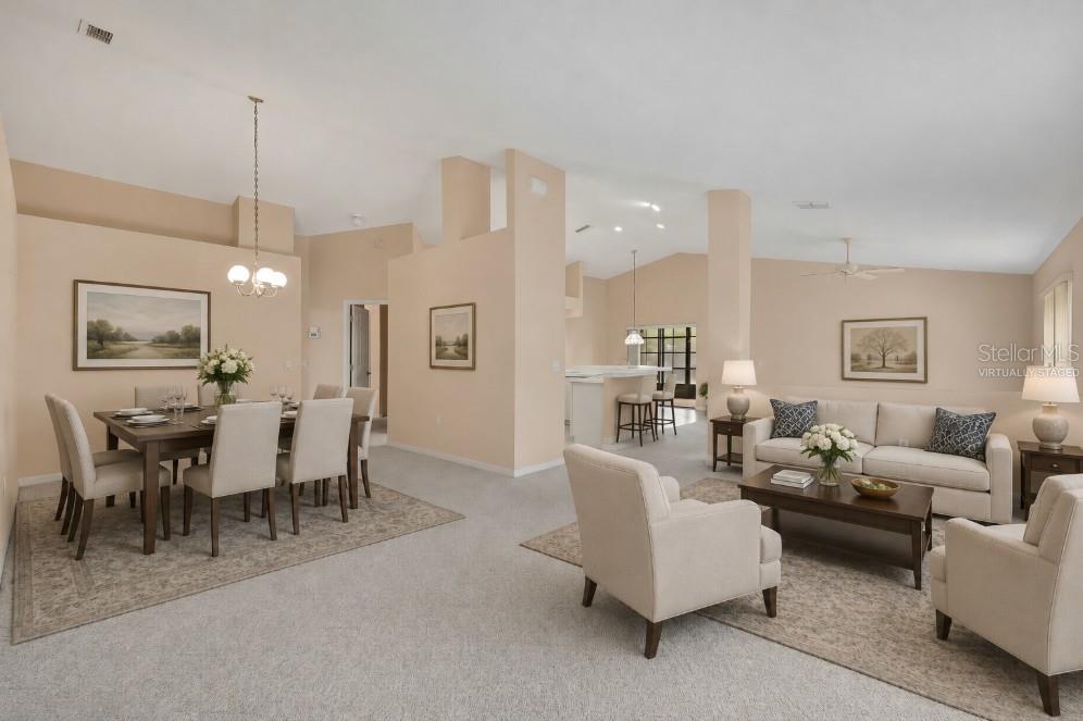 An open-concept living and dining area with neutral walls, carpeted floors, and vaulted ceilings — 11103 CHERRYWOOD COURT, SPRING HILL, FL
