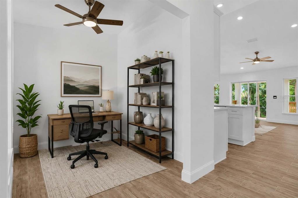 A home office with a wooden desk, metal shelving, and a ceiling fan on tile floors — 300 CHEROKEE AVENUE, ORANGE CITY, FL