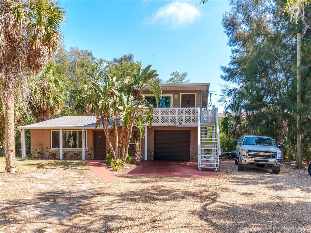 A two-story house with a garage, a second-floor balcony, and a gravel driveway — 4910 LIMESTONE DRIVE, PORT RICHEY, FL