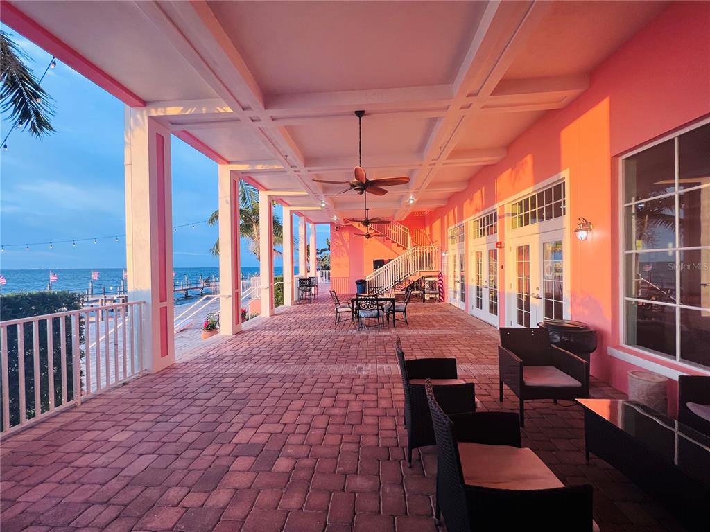 A canal view featuring docked boats alongside a residential building with white outdoor staircases — 5020 BEACH DRIVE SE UNIT D, ST PETERSBURG, FL