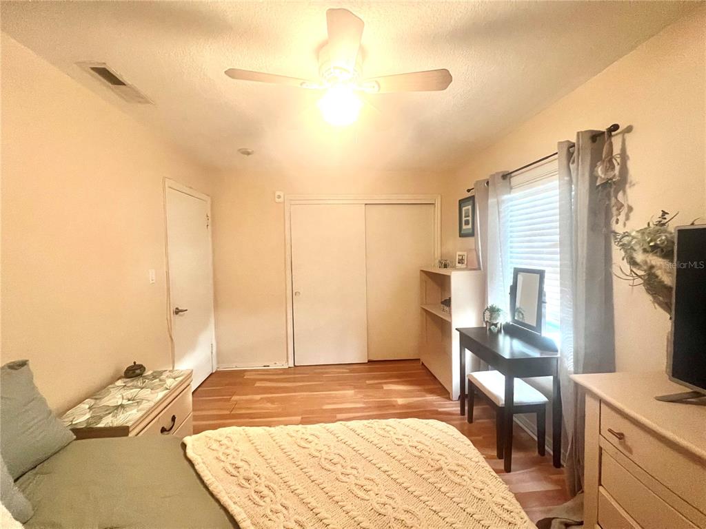 A dining area with a glass table, yellow chair, and a view into the kitchen — 5020 BEACH DRIVE SE UNIT D, ST PETERSBURG, FL