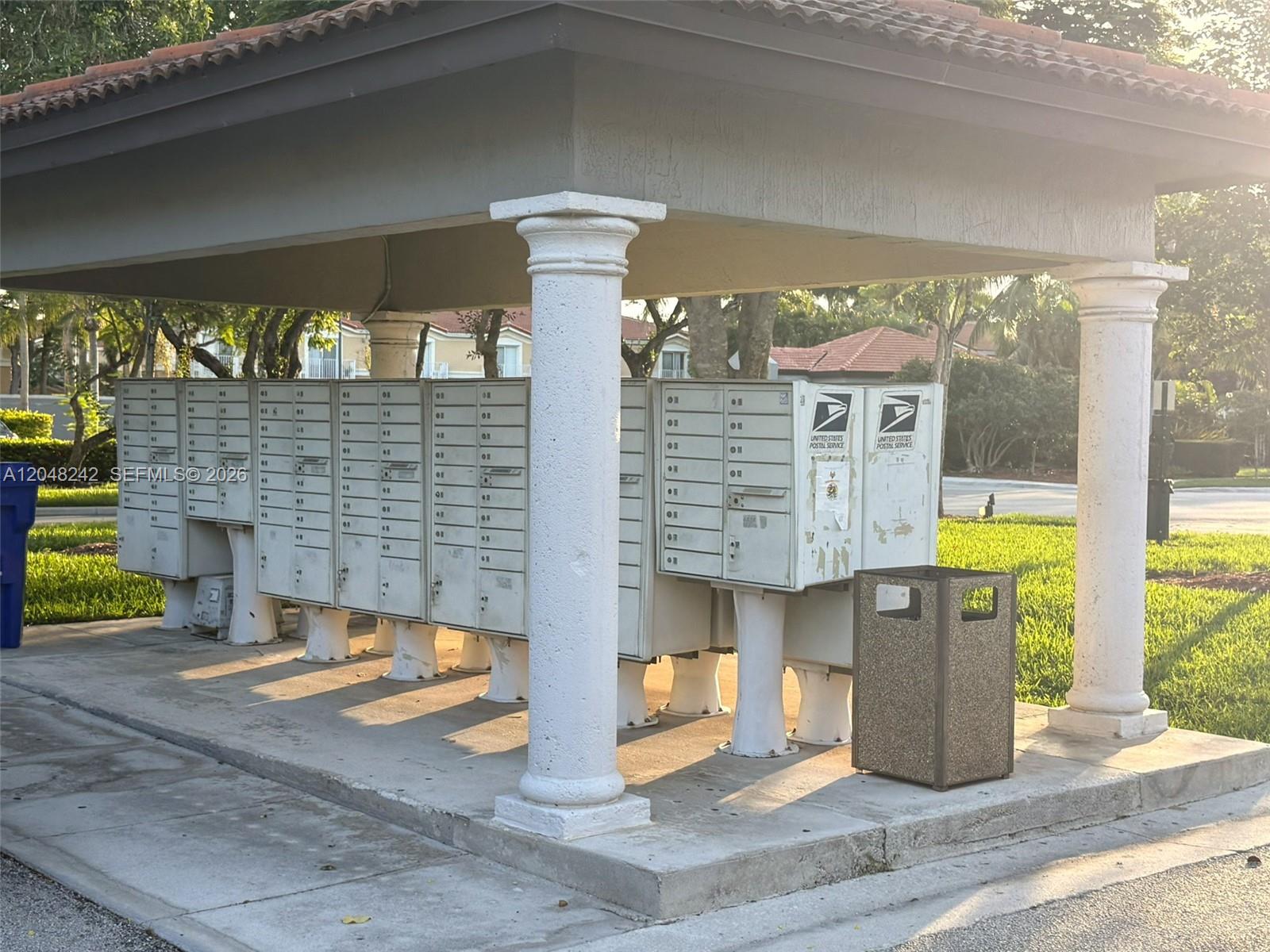 A covered outdoor structure features rows of metal mailboxes supported by white columns — 12821 SW 29th St, Miramar FL 33027, MIRAMAR, FL