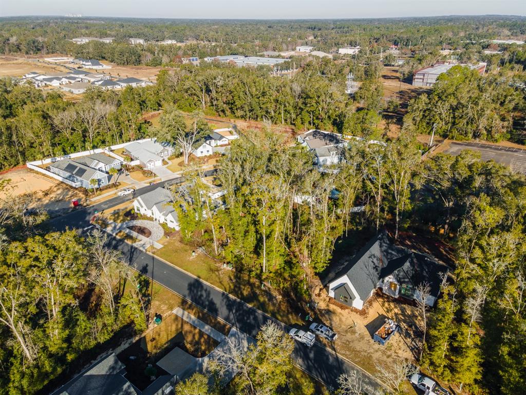 An aerial view shows several modern houses nestled among trees in a suburban neighborhood — 14110 SW 7TH PLACE, NEWBERRY, FL