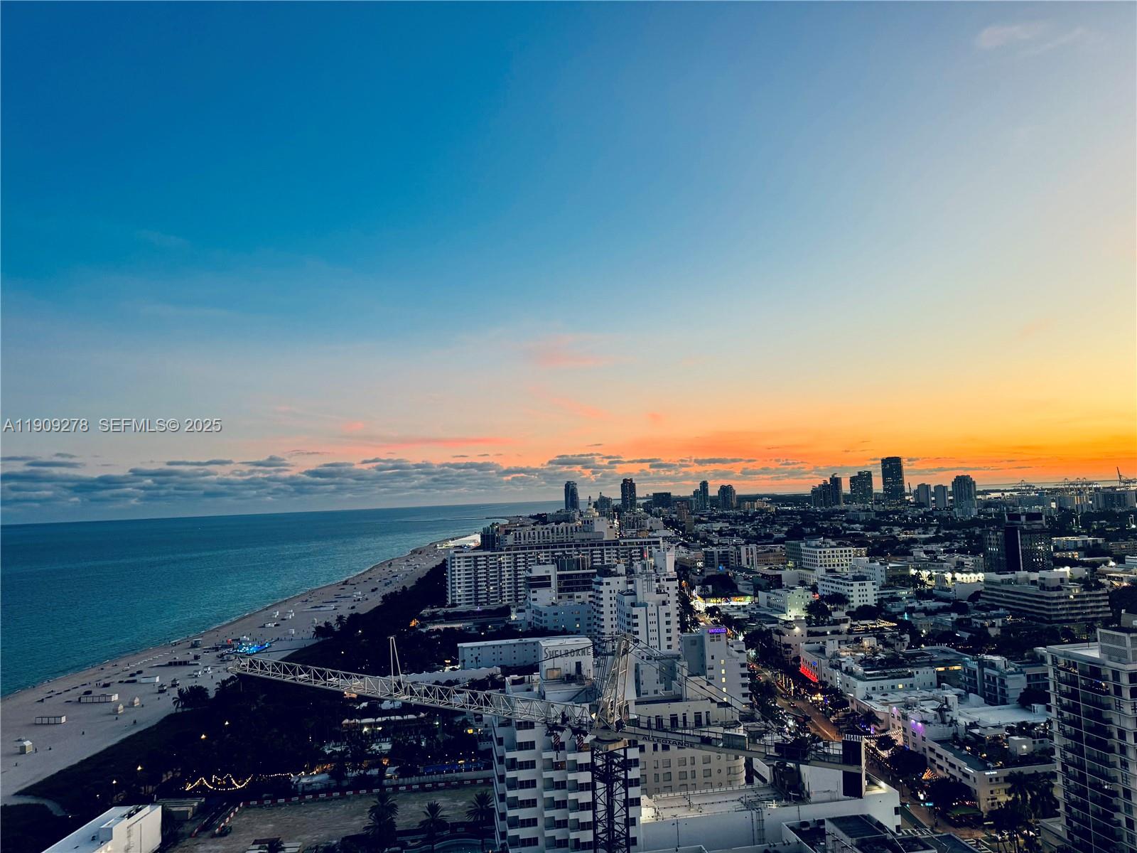 An elevated view of a coastal city skyline at sunset with a beach and construction crane — 101 20th St # 3202, Miami Beach FL 33139, MIAMI BEACH, FL