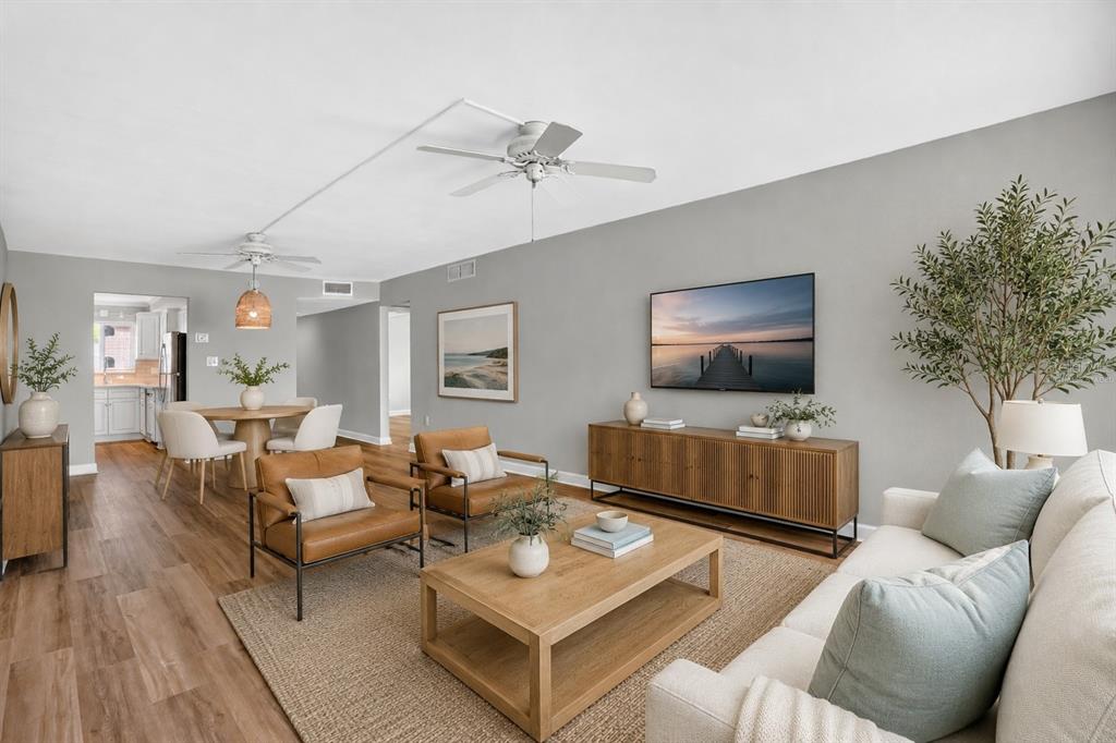 A living room with light wood floors, gray walls, a sofa, and two leather chairs — 4570 OVERLOOK DRIVE NE UNIT 175, ST PETERSBURG, FL