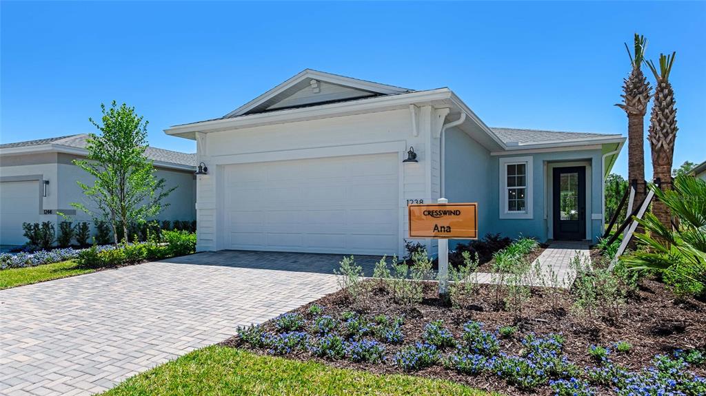 A single-story house with a white garage, light blue siding, and a paved driveway — 1278 EDEN ROCK COURT, DELAND, FL