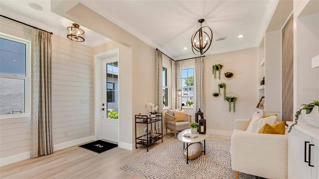 A bright living room features shiplap walls, a patterned area rug, and a modern chandelier — 1278 EDEN ROCK COURT, DELAND, FL