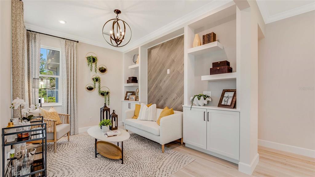 A living room features a white sofa, built-in shelving, and a wood-paneled accent wall — 1278 EDEN ROCK COURT, DELAND, FL