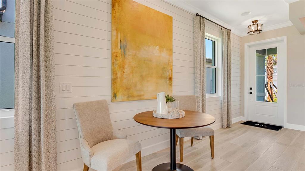 A dining nook features shiplap walls, a round wooden table, two chairs, and a front door — 1278 EDEN ROCK COURT, DELAND, FL