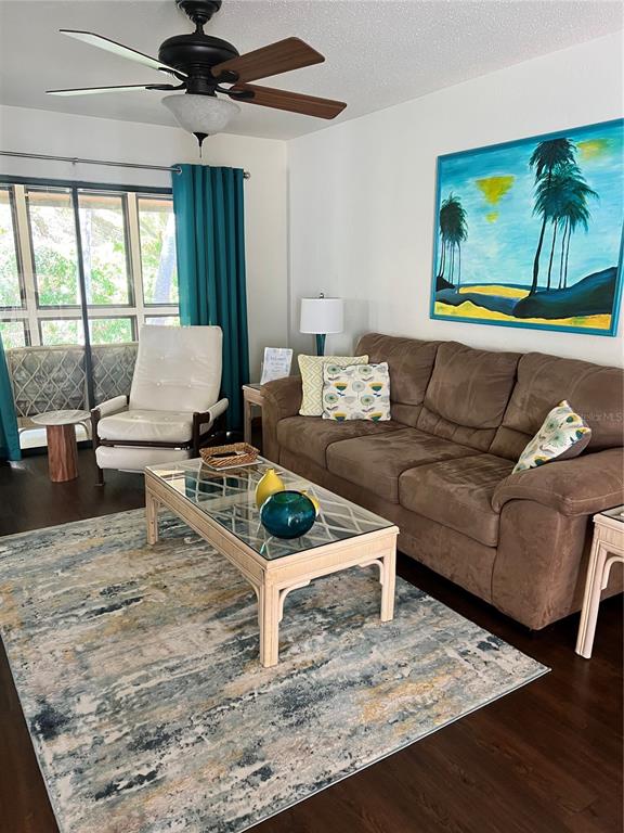 A living room features a brown sofa, a glass-topped coffee table, and a ceiling fan — 10 OAKMONT COURT UNIT 10, PALM COAST, FL