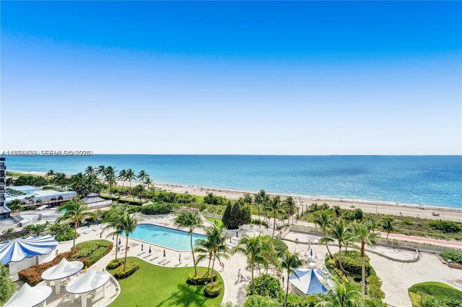 An aerial view shows a swimming pool, palm trees, and a beach along the ocean — 5151 Collins Ave # 1035, Miami Beach FL 33140, MIAMI BEACH, FL