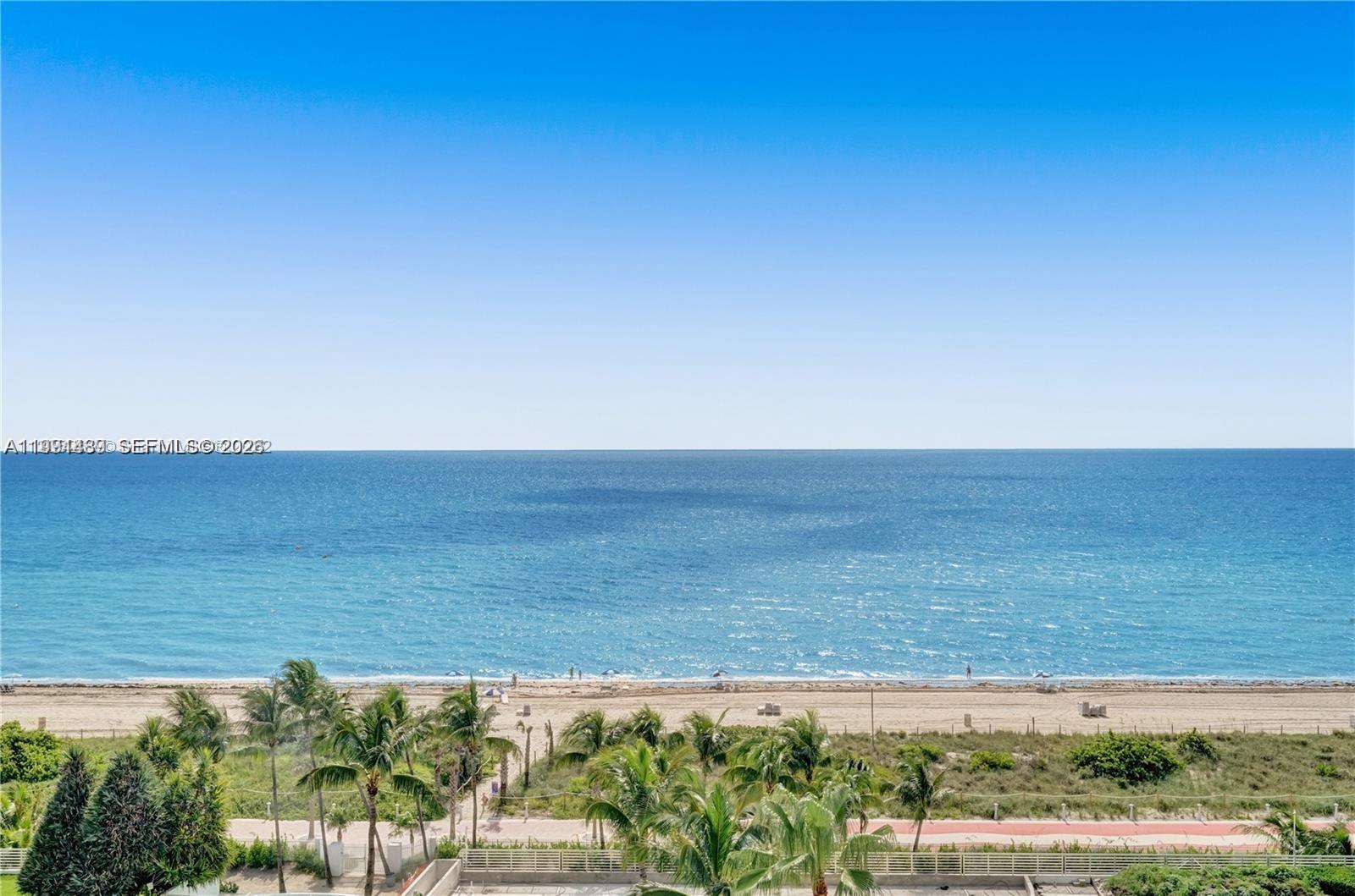 An elevated view shows a sandy beach, palm trees, and the ocean under a clear sky — 5151 Collins Ave # 1035, Miami Beach FL 33140, MIAMI BEACH, FL
