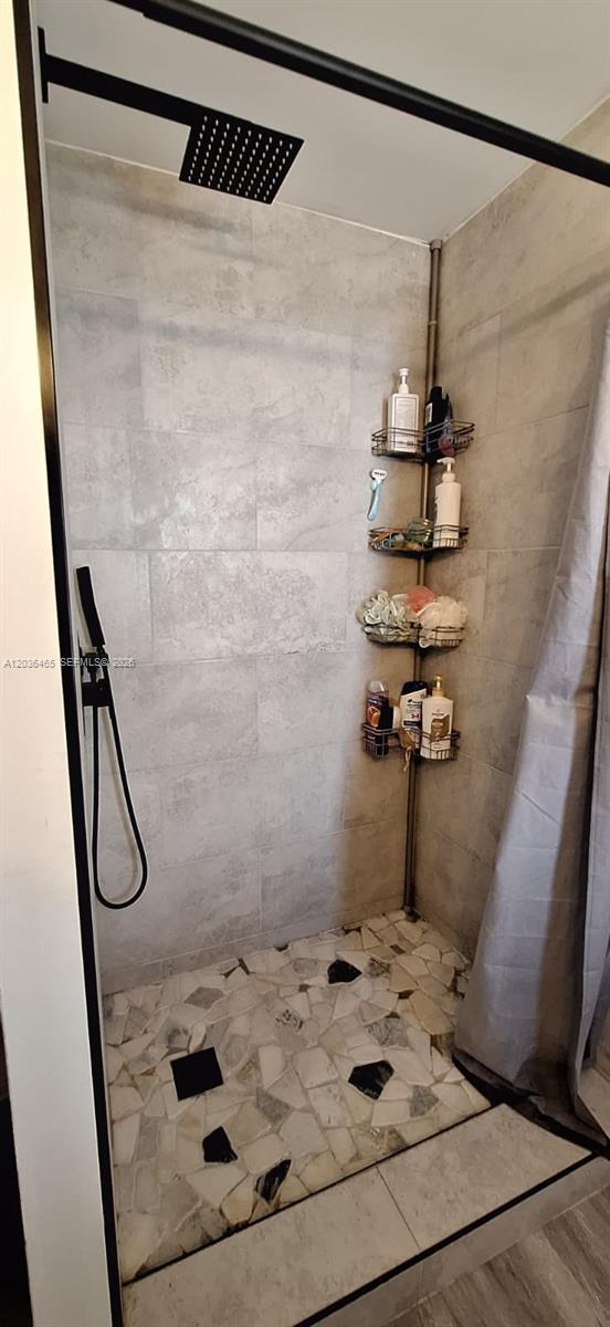 A walk-in shower features gray tile walls, a rainfall showerhead, and a mosaic stone floor — 4701 SW 73, Davie FL 33314, DAVIE, FL