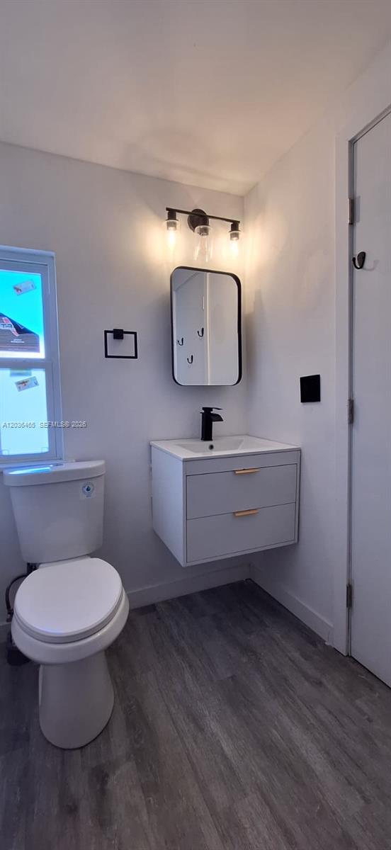 A bathroom features a floating vanity, a wall-mounted mirror, a toilet, and wood-look flooring — 4701 SW 73, Davie FL 33314, DAVIE, FL