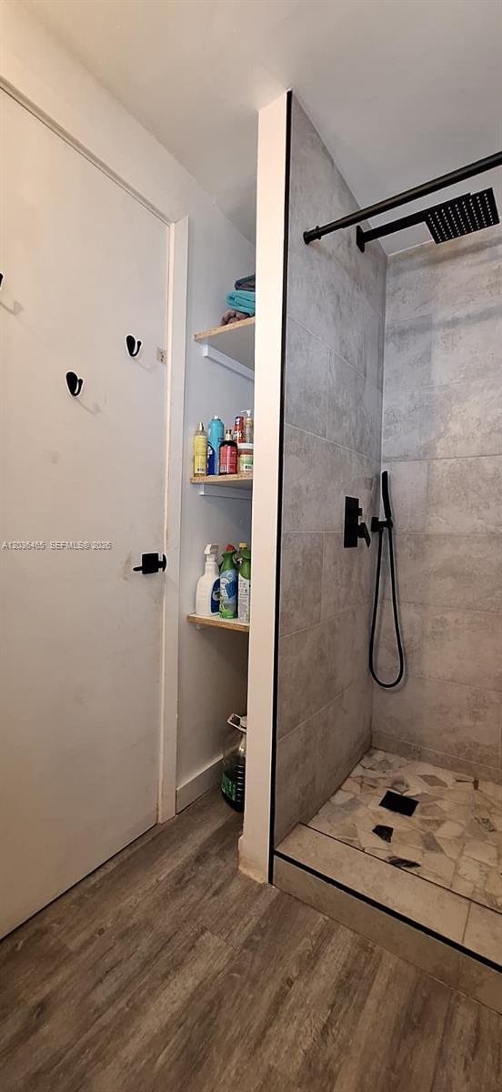 A bathroom features a tiled walk-in shower next to a wall with built-in open shelving — 4701 SW 73, Davie FL 33314, DAVIE, FL