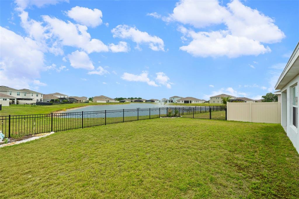 A dining area with a round table and sliding glass doors overlooking a pond — 12210 KINGSLEY TRAIL, PARRISH, FL