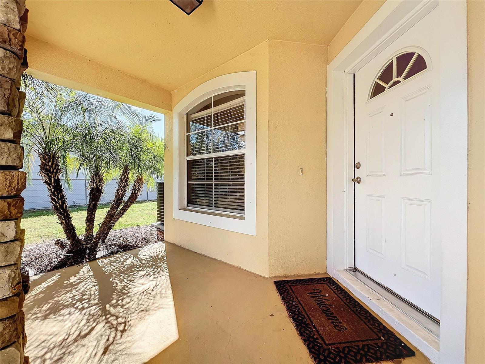 A covered porch features a white front door, a large arched window, and a palm tree — 2560 Franklin Avenue, Winter Park FL 32789, WINTER PARK, FL