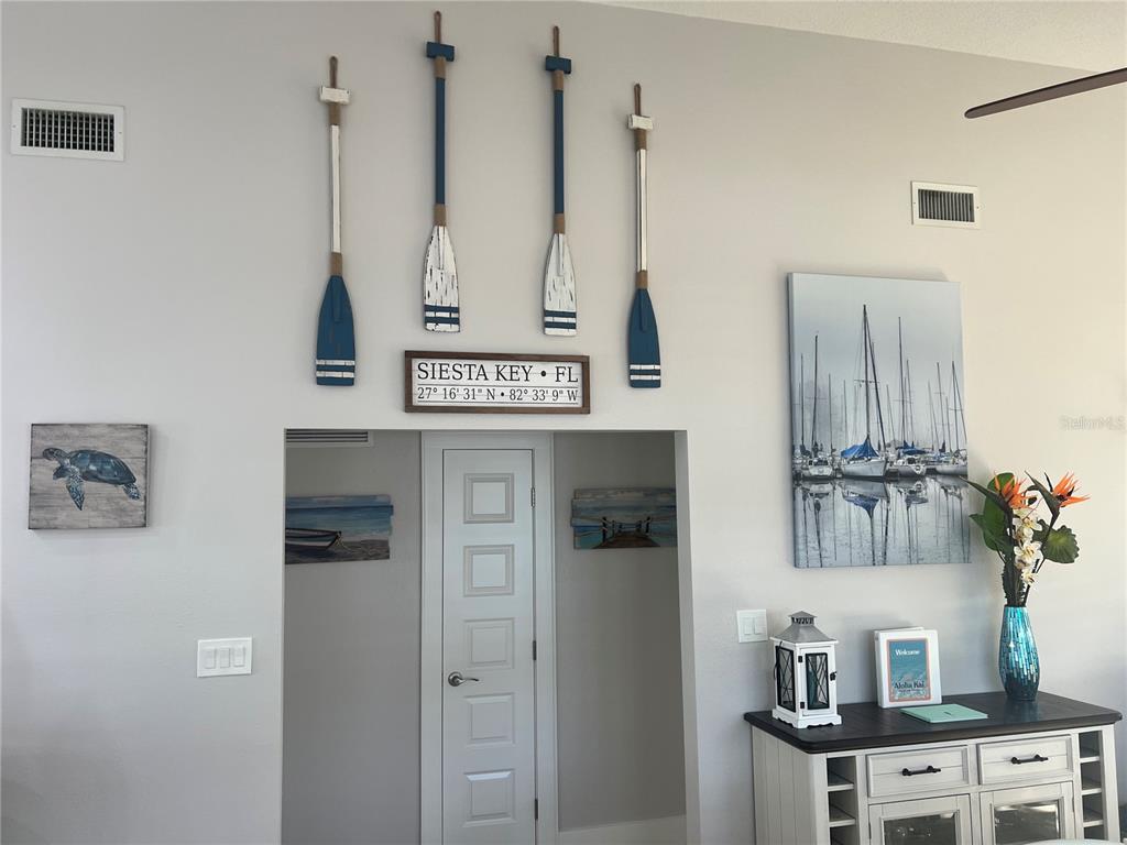 A coastal-themed living area features four decorative oars mounted above a doorway with a sign — 6020 MIDNIGHT PASS ROAD UNIT 22, SARASOTA, FL