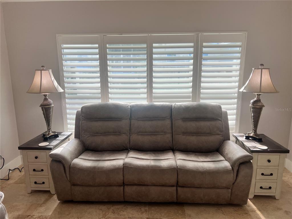 A gray reclining sofa is centered between two matching end tables with lamps — 6020 MIDNIGHT PASS ROAD UNIT 22, SARASOTA, FL
