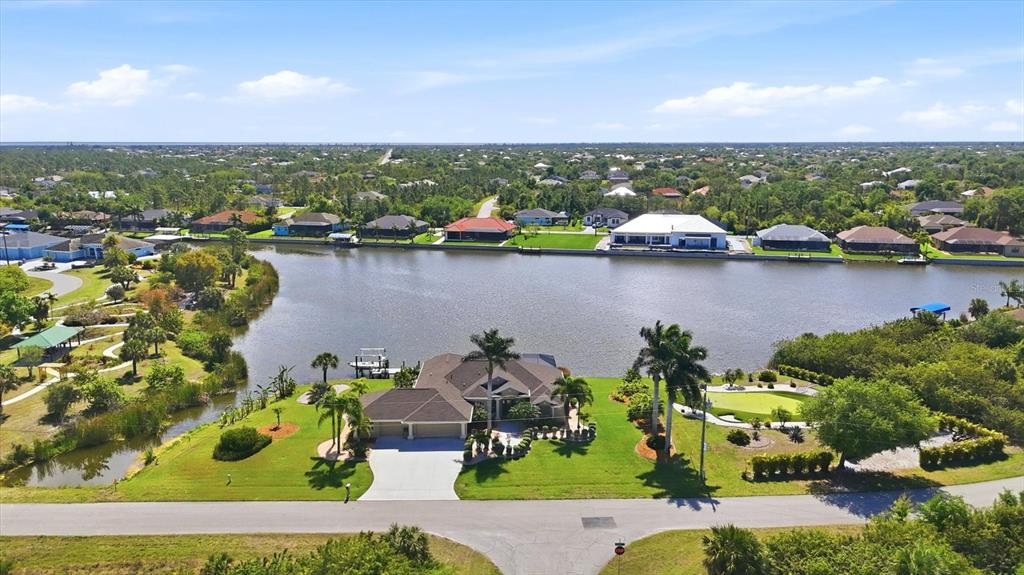An aerial view shows a waterfront house with a putting green and boat dock — 13561 BLAKE DRIVE, PORT CHARLOTTE, FL