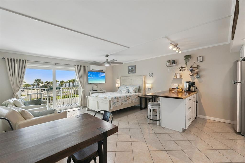 A studio apartment features a bed, kitchenette, dining table, and a balcony with ocean views — 3700 S ATLANTIC AVENUE UNIT 309, NEW SMYRNA BEACH, FL