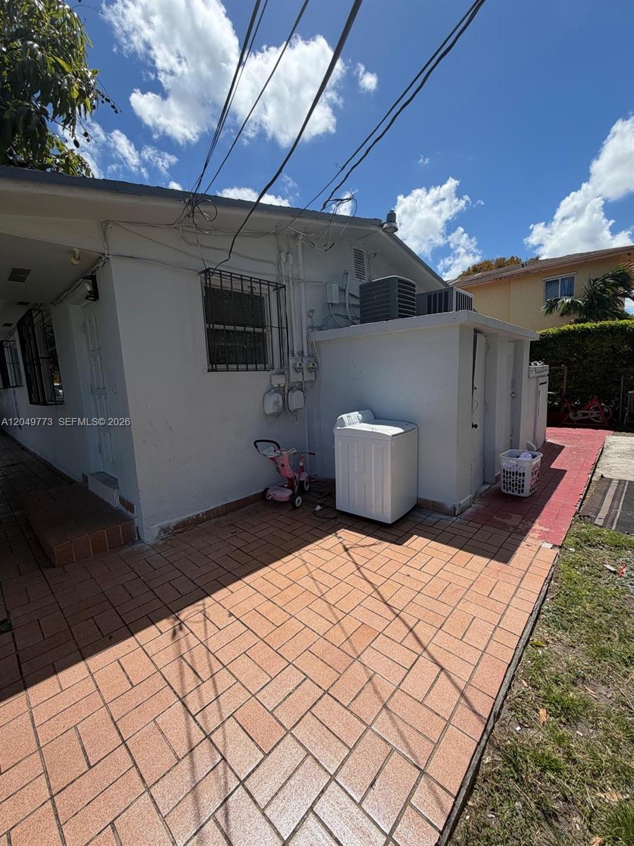 An exterior view shows a white building with a tiled patio and a washing machine — 41 E 20th St, Hialeah FL 33010, HIALEAH, FL