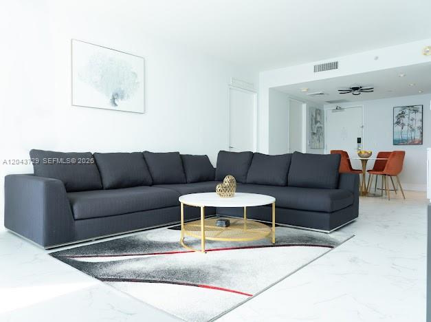 A living room features a large dark gray sectional sofa, a round coffee table, and rug — 1100 West Ave # 510, Miami Beach FL 33139, MIAMI BEACH, FL