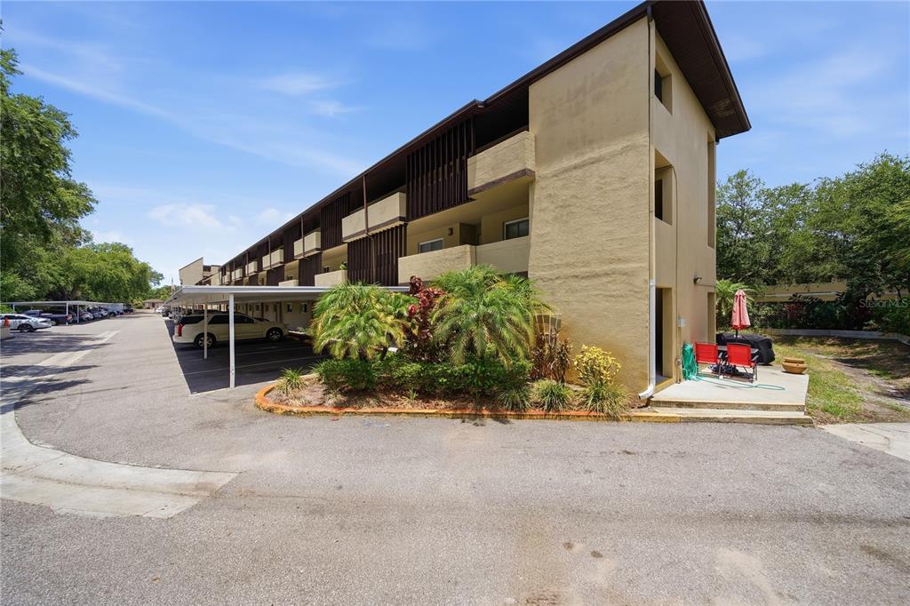 A multi-story apartment building with covered parking and a small landscaped area in front — 1247 S MARTIN LUTHER KING JR AVENUE UNIT 107, CLEARWATER, FL