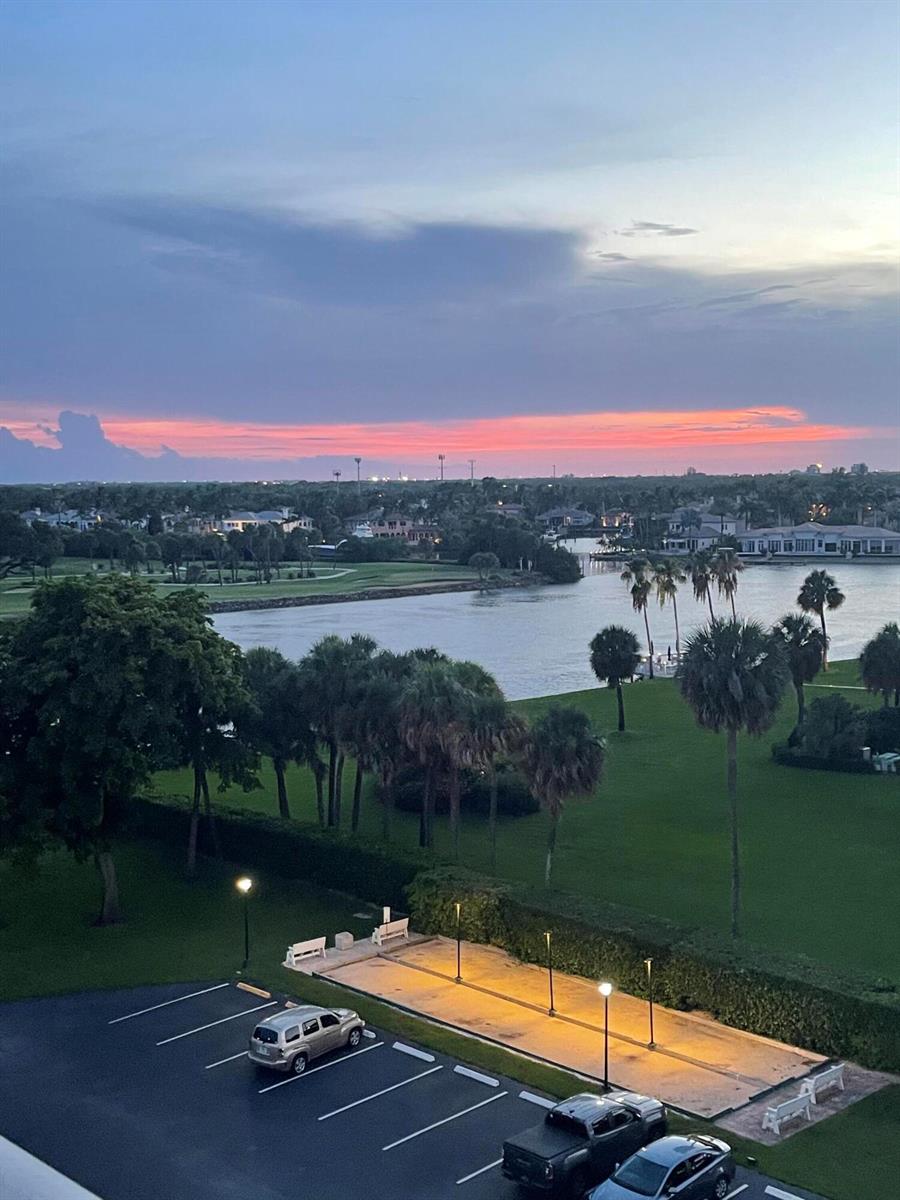An elevated view of a parking lot, a bocce court, palm trees, and a waterfront landscape — 336 Golfview Road # 706, North Palm Beach FL 33408, NORTH PALM BEACH, FL
