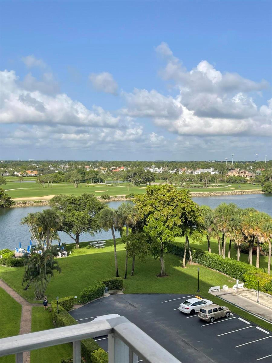An elevated view of a golf course, a lake, and a parking lot with cars — 336 Golfview Road # 706, North Palm Beach FL 33408, NORTH PALM BEACH, FL