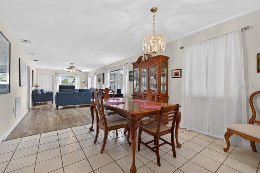 A dining area with a wooden table and hutch opens into a living room — 5357 81ST STREET N UNIT 12, ST PETERSBURG, FL