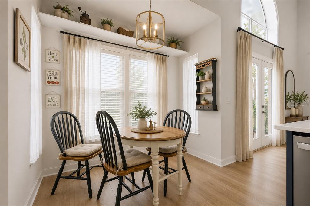 A bright breakfast nook features a round wooden table, black chairs, and a hanging light — 13200 MALLARD COVE BOULEVARD, ORLANDO, FL