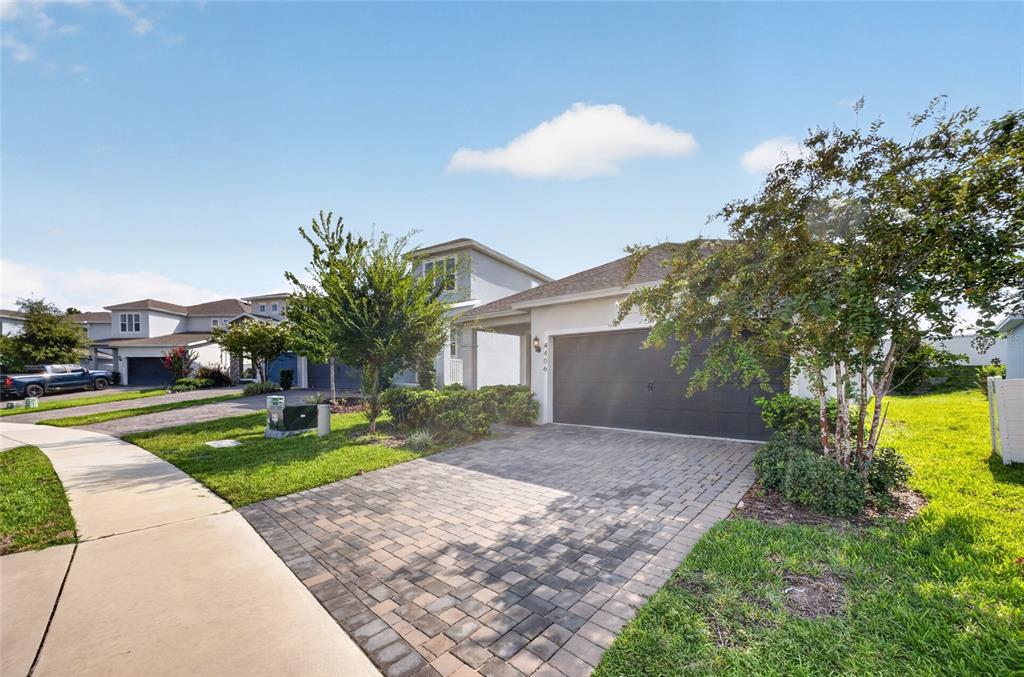 A single-story house with a paved driveway, a two-car garage, and a landscaped front yard — 4406 DAVOS DR, CLERMONT, FL