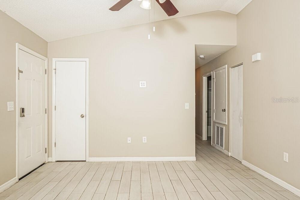 An interior view of a room with light-colored tile flooring, white walls, and multiple doors — 2912 CRANE AVENUE, NORTH PORT, FL