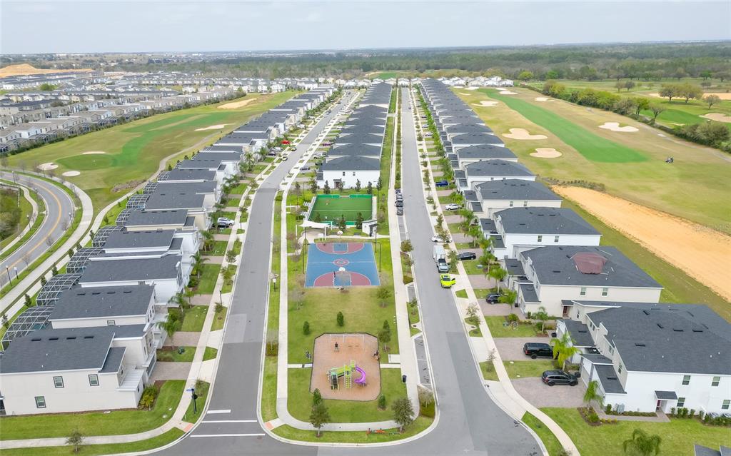 An aerial view shows a suburban neighborhood with houses, a playground, and a basketball court — 815 OCEAN COURSE AVENUE UNIT 815, DAVENPORT, FL