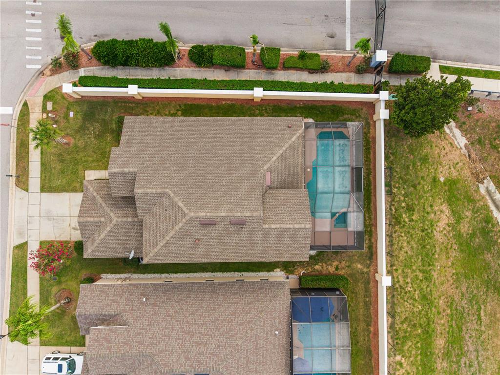 An aerial view of a yellow suburban house with a two-car garage at sunset — 8184 FAN PALM WAY, KISSIMMEE, FL