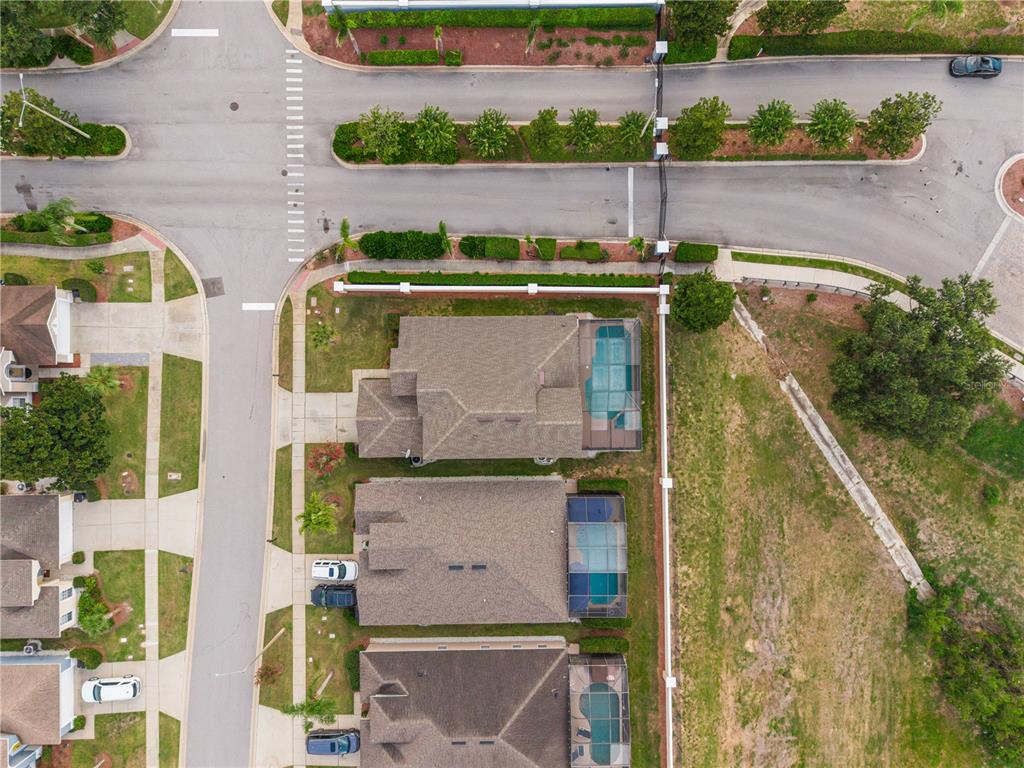 A beige two-story house features a white garage door and an arched entryway — 8184 FAN PALM WAY, KISSIMMEE, FL