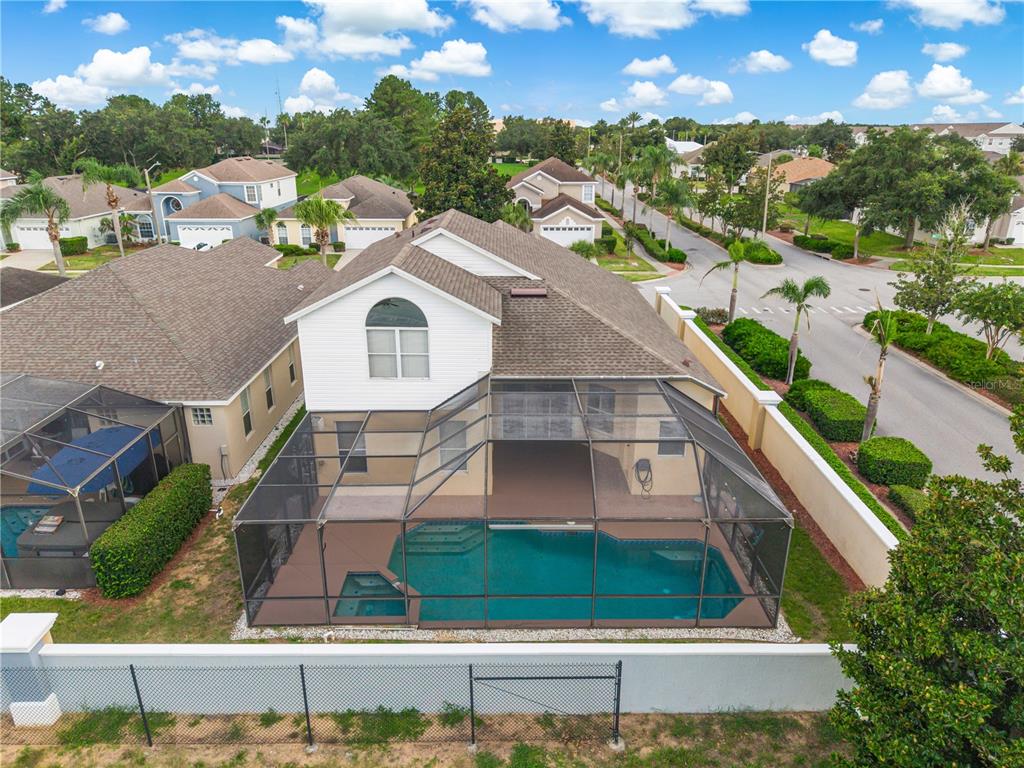 An aerial view shows two suburban houses with driveways and lawns near a small lake — 8184 FAN PALM WAY, KISSIMMEE, FL