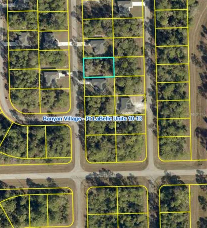 This is an aerial map showing a vacant lot outlined in blue within a residential subdivision — 909 EMERALD STREET, LABELLE, FL