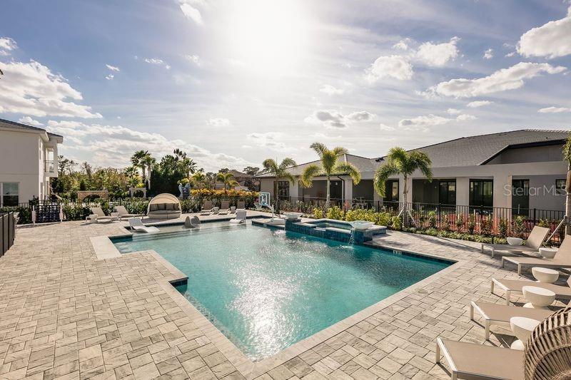 A rectangular swimming pool with a spa and lounge chairs on a paved patio — 1008 COYOTE CREEK WAY, REUNION, FL