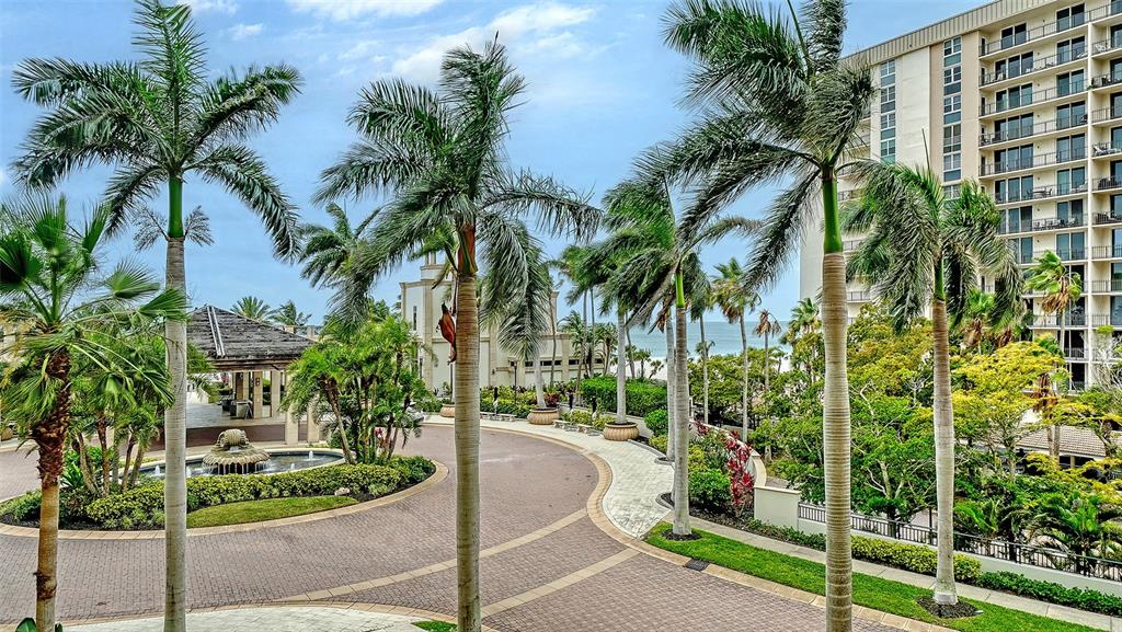 A paved circular driveway leads to a resort building surrounded by palm trees and landscaping — 1300 BENJAMIN FRANKLIN DRIVE UNIT 301, SARASOTA, FL