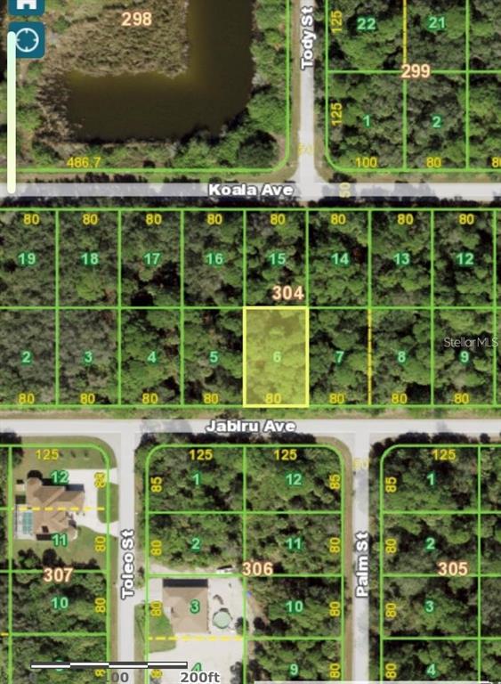 This is a satellite map showing a highlighted vacant residential lot among wooded parcels — 18052 JABIRU AVENUE, PORT CHARLOTTE, FL