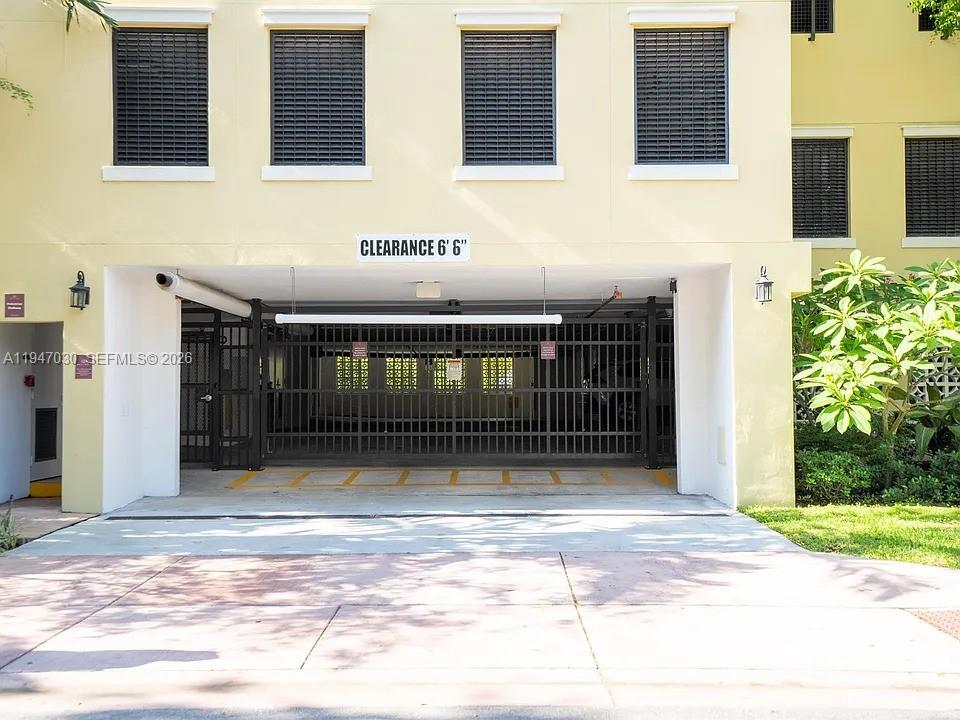 A gated parking garage entrance features a clearance sign and a concrete driveway — 1091 Galiano St, Coral Gables FL 33134, CORAL GABLES, FL