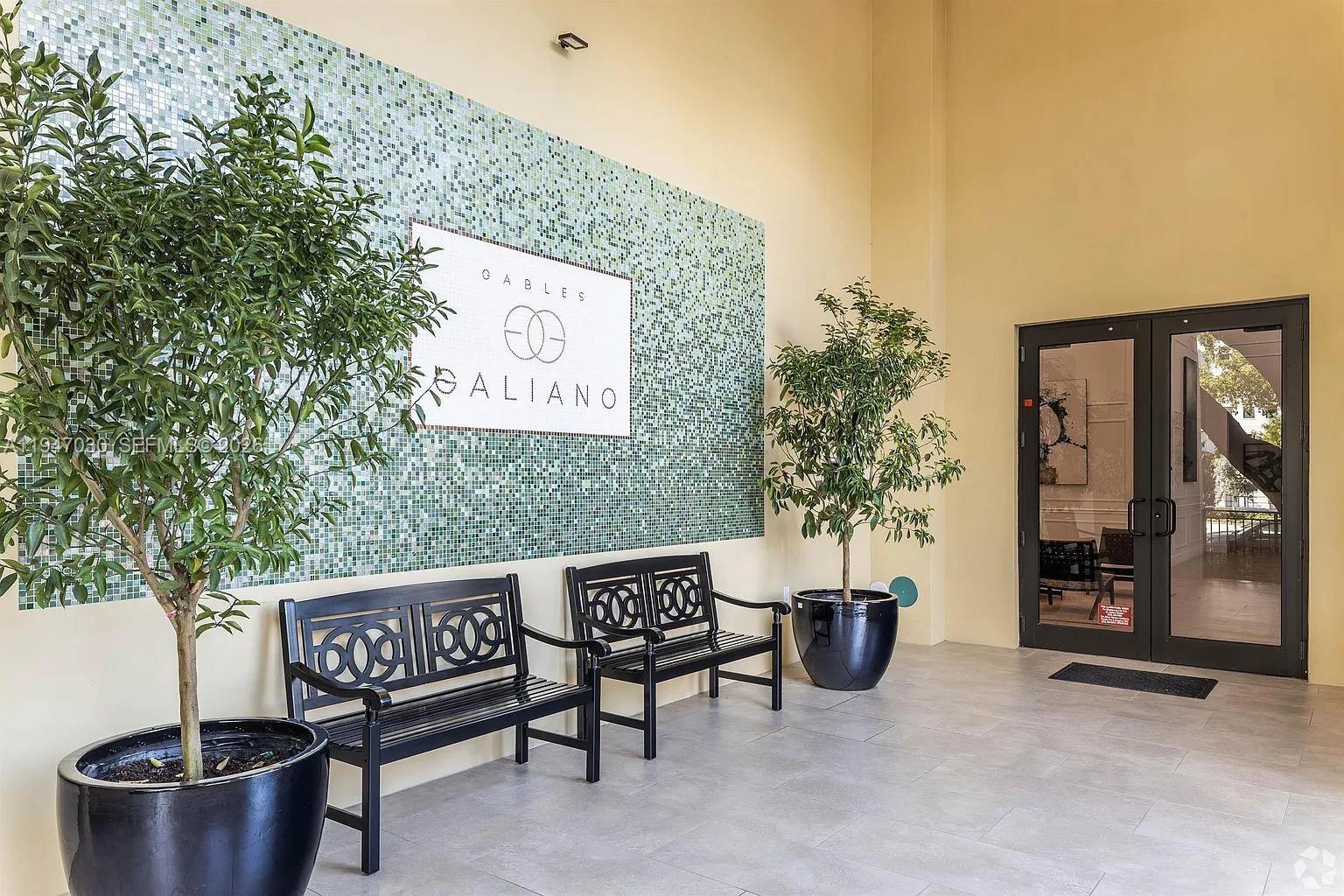 A building entrance features two black benches, potted trees, and a mosaic tile wall — 1091 Galiano St, Coral Gables FL 33134, CORAL GABLES, FL